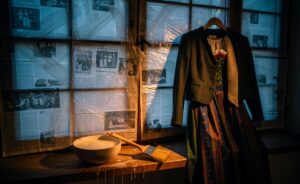 Illustration von mit Kartoffelstärke laminiertem Zeitungspapier am Fenster als tragfähigem Schutz für angelehnte Trachten